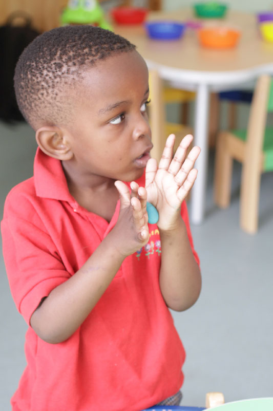 Preschool boy rolling plasticine